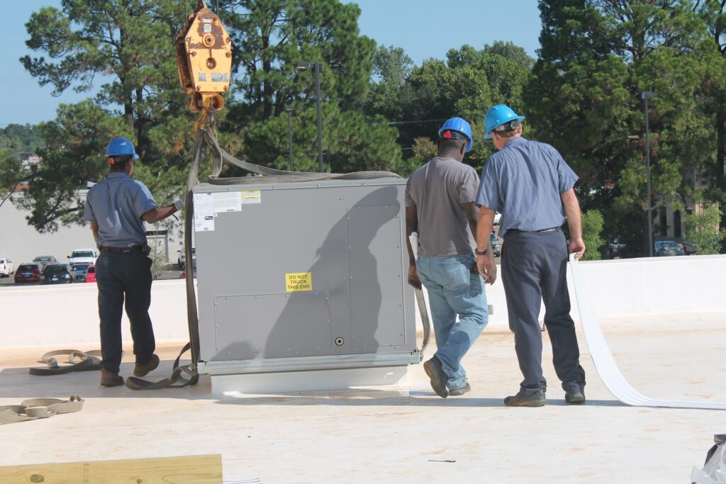 A Tyler Weathermakers crew craning a rooftop HVAC unit into place on a commercial building
