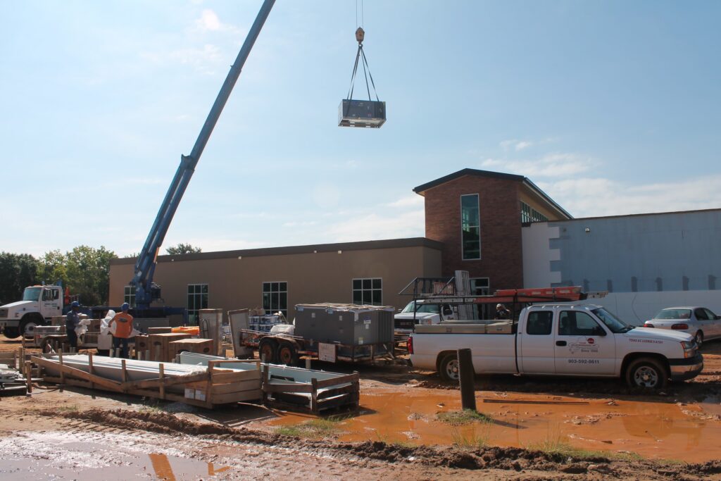 A Tyler Weathermakers crew setting a new HVAC unit on a job site